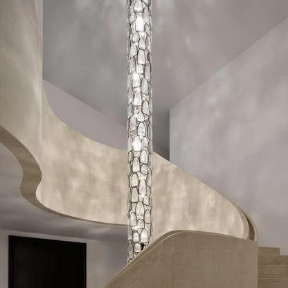Crystal glass column pendant lamp creating soft reflections in a stairwell interior